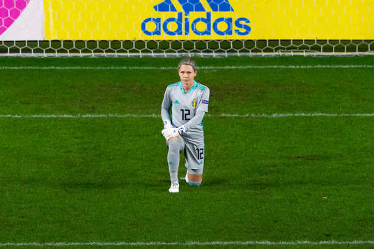 Goalkeeper Jennifer Falk of Sweden kneels in support of the