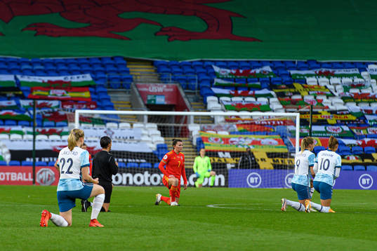 Players of Norway and Wales kneel in support of the "Black