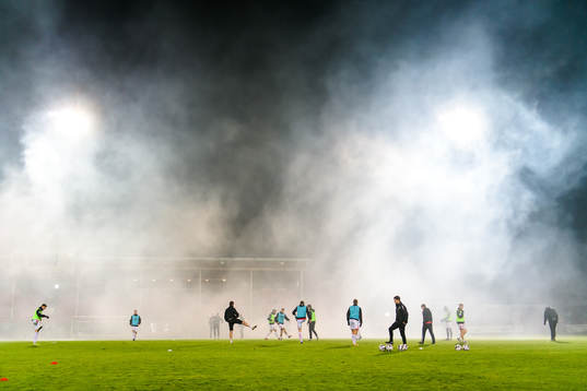 Rök från supportrar utanför planen väller in när