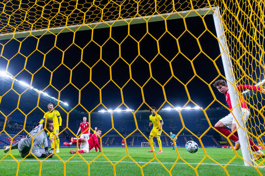 Jonas Wind of Denmark scores 1-0 behind goalkeeper