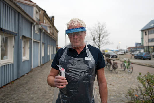 Distriktsläkare Sverker Nilsson håller i ett covid-test