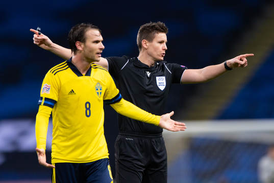 Albin Ekdal of Sweden reacts beside referee Daniel Siebert