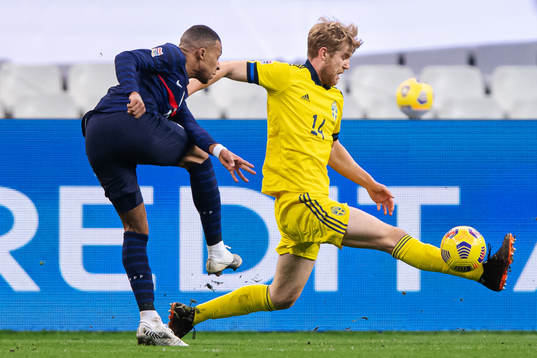 Kylian Mbappé of France and Filip Helander of Sweden