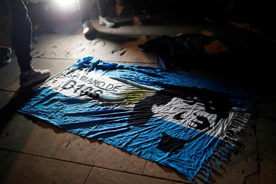 An Argentine flag with the face of late Argentine soccer