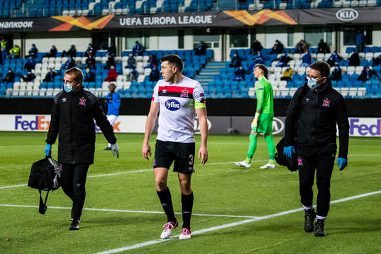 Brian Gartland of Dundalk walks off the pitch with an injury