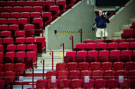 En fotograf på läktaren i en tom Malmö arena