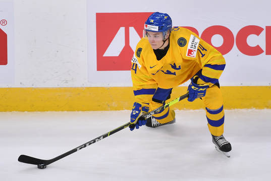 Arvid Costmar of Sweden skates with the puck
