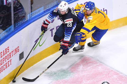 Ryan Johnson of USA skates with the puck while Lucas