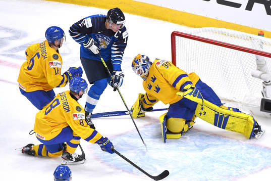 Anton Lundell of Finland takes the puck to Sweden's net