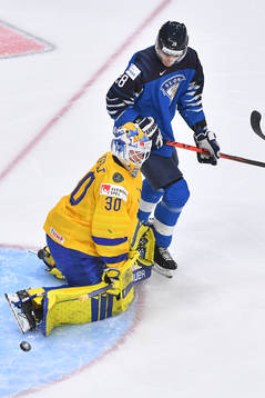 Hugo Alnefelt of Sweden makes a save with Henri Nikkanen of