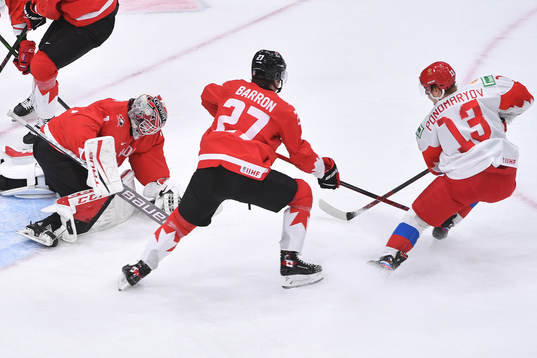 Devon Levi of Canada makes a save with Vasili Ponomaryov of
