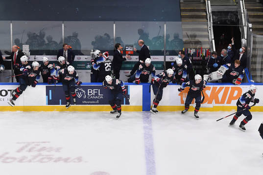 Team USA jumps off their bench to celebrate their 4-3