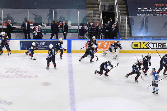 Team USA jumps off their bench to celebrate their 4-3