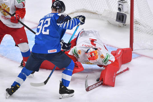 Yaroslav Askarov of Russia smothers the puck with Matias