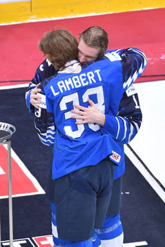 Team captain Anton Lundell of Finland hugs teammate Brad