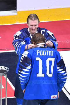 Team captain Anton Lundell of Finland presents teammate