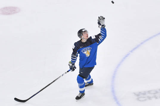 Ville Heinola of Finland reaches for a flying puck