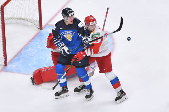Benjamin Korhonen of Finland tires to defect a flying puck