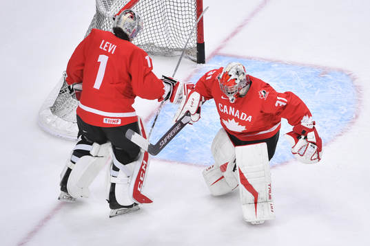 Dylan Garand and Devon Levi of Canada exchange spots