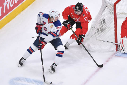 Trevor Zegras of USA protects the puck from Connor