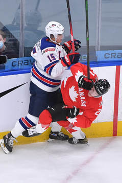 Alex Turcotte of USA knocks down Kaiden Guhle of Canada