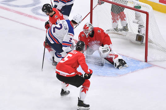 Devon Levi of canada makes a save as Drew Helleson of USA