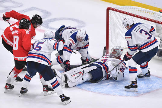 Dylan Cozens and Peyton Krebs of Canada dig at the puck