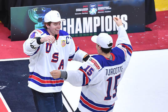 Cam York of USA hugs teammate Alex Turcotte