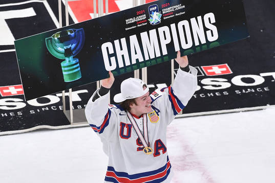 Cole Caufield of USA holds up championship sign
