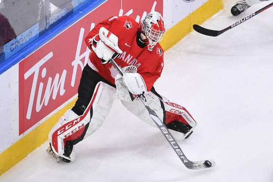Devon Levi of Canada wanders out of his net to play the puck