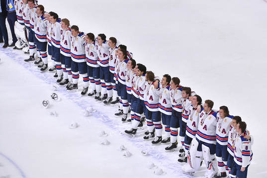 Team USA stands arm in arm singing their national anthem