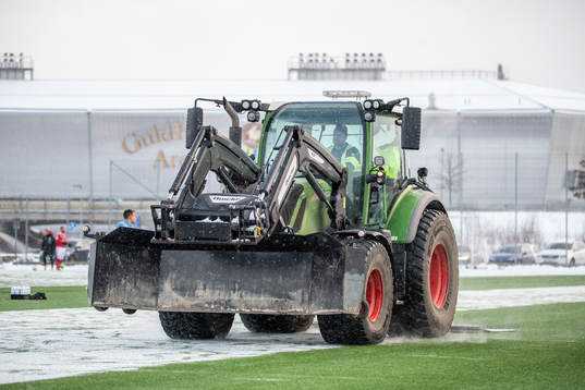 En traktor skottar snö från fotbollsplanen