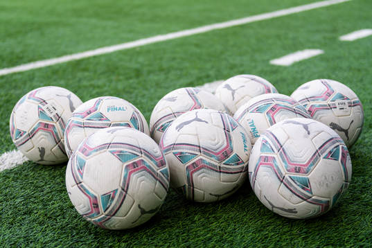 Fotbollar ligger på konstgräsmattan
