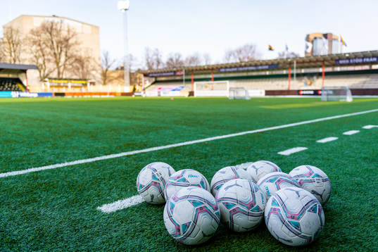 Fotbollar ligger på konstgräsmattan