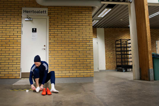 Linus Hallenius knyter på sig sina skor innan en träning