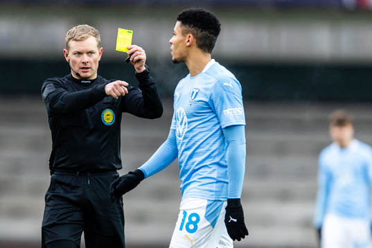 Domare Fredrik Klitte delar ut gult kort till Malmö FFs