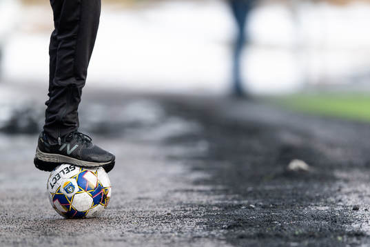 Bollkalle som står på en fotboll