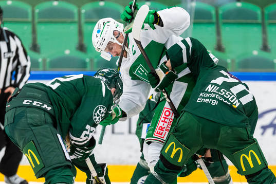 Rögles Mattias Sjögren i kamp om pucken med Färjestads