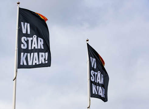 Flaggor med texten VI STÅR KVAR innan ishockeymatchen i