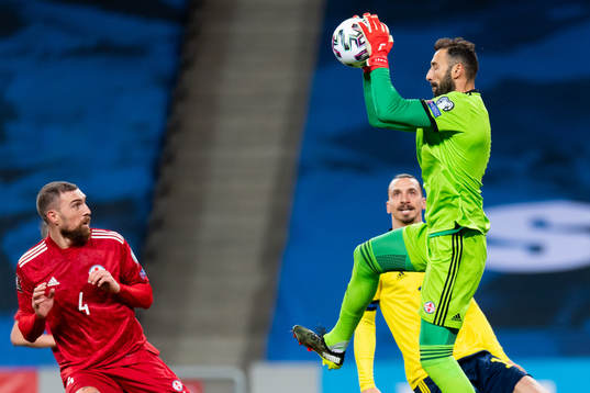 Guram Kashia and goalkeeper Giorgi Loria of Georgia against