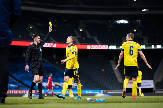 Ludwig Augustinsson of Sweden is shown a yellow card