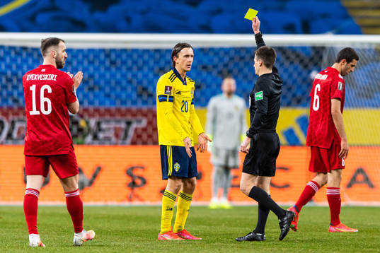 Kristoffer Olsson of Sweden receives a yellow card from