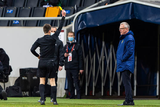 Referee Bastien Benoit awards a yellow card to Janne
