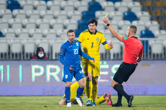 Bernard Berisha of Kosovo receives a yellow card from