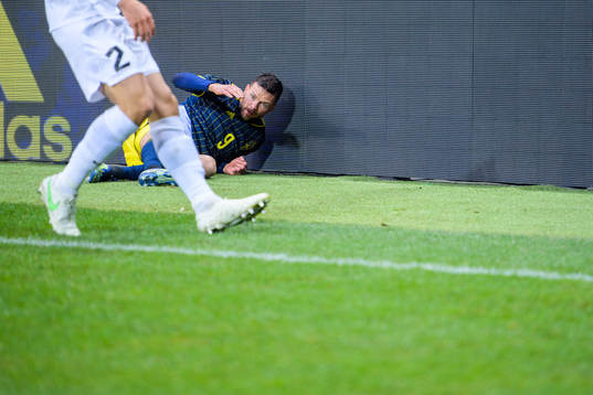 Marcus Berg of Sweden fall into a commercial sign