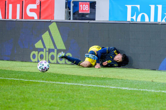 Marcus Berg of Sweden fall into a commercial sign