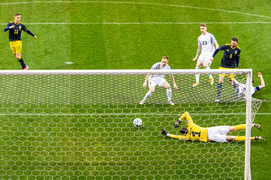 Marcus Berg of Sweden scores 1-0 behind goalkeeper Matvei