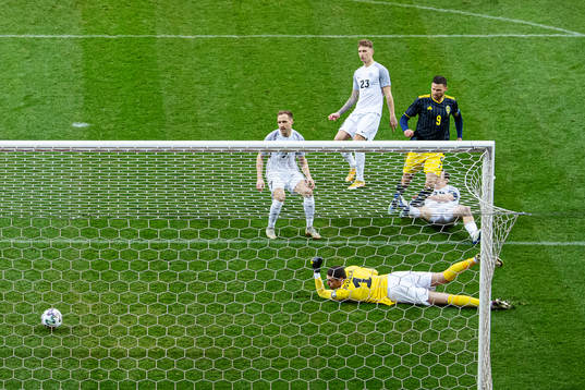 Marcus Berg of Sweden scores 1-0 behind goalkeeper Matvei