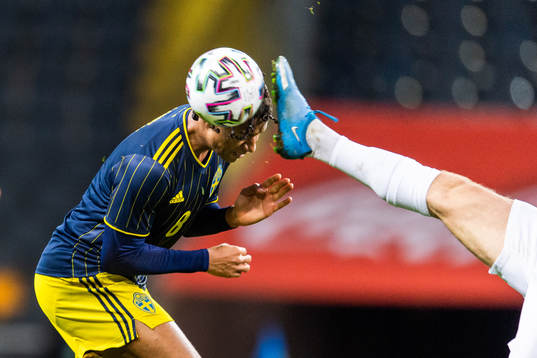 Jens-Lys Cajuste of Sweden is hit by a foot