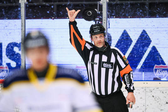 Domare Mikael Nord gör tecken för att ringa på ett